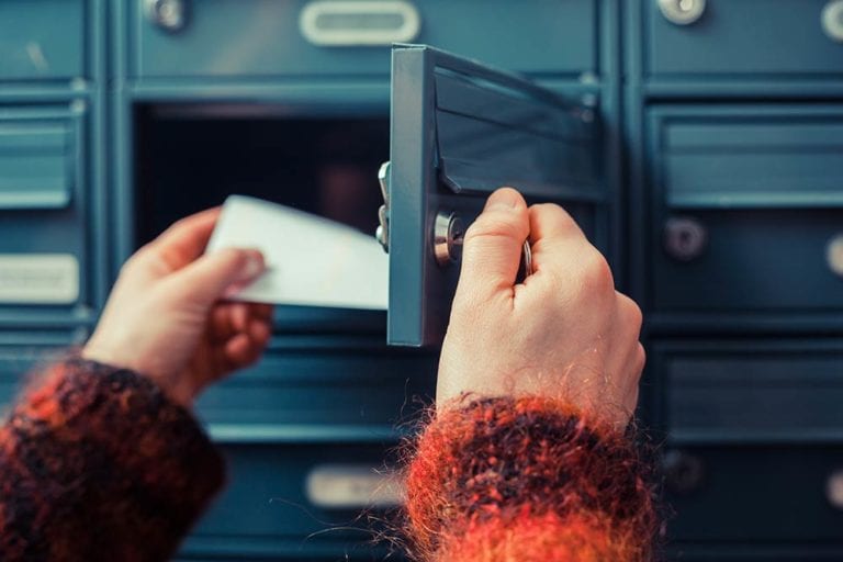 Person checking post office box for mail