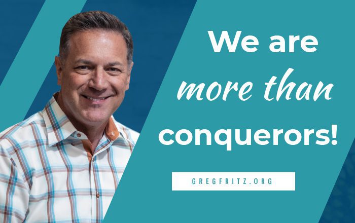 Greg Fritz smiling next to the words: we are more than conquerors!